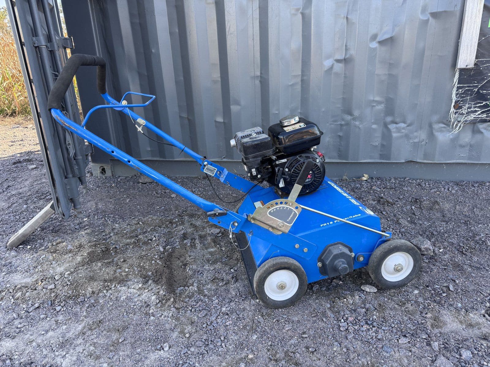 Blue Bluebird PR18 power rake with a Honda engine, parked on gravel