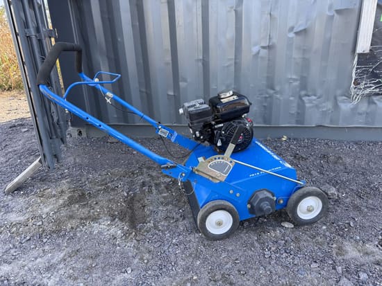 Blue Bluebird PR18 power rake with a Honda engine, parked on gravel