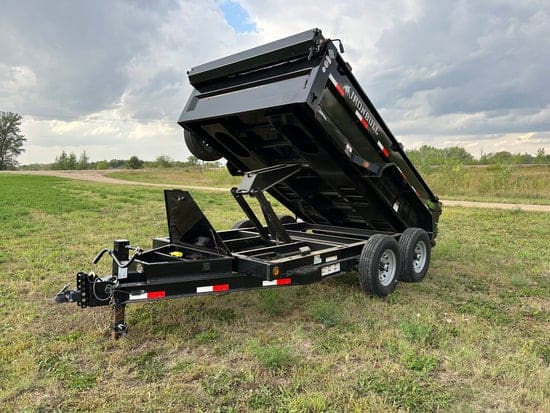 Black tandem-axle dump trailer with the bed raised